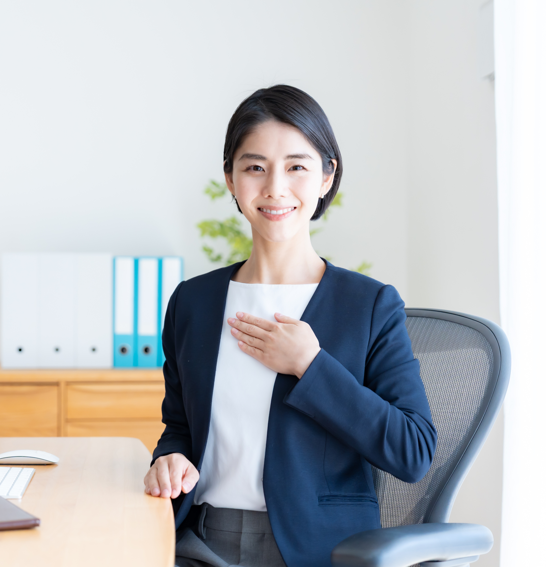 オフィスで穏やかに微笑むスーツ姿の女性のイメージ