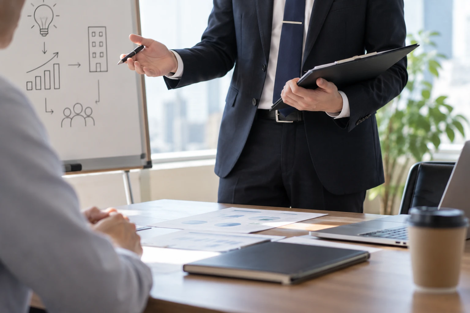 ホワイトボードの前で事業計画を説明するコンサルタント